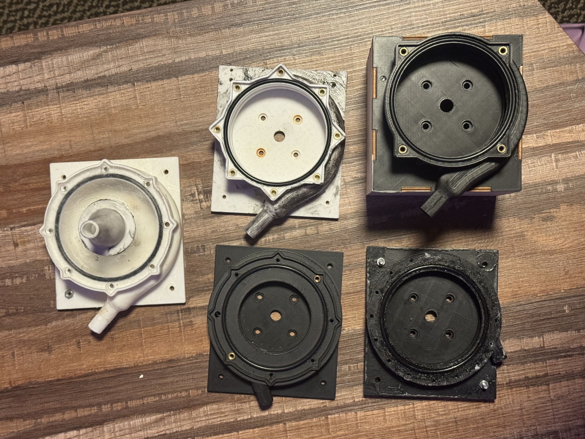 Annotated exploded view naming volutes, impellers, magnetic transmission plates, end caps, polycarbonate casing, stator, BLDC motor, magnets, motor shaft and dowel pins